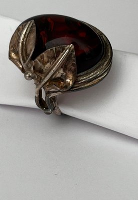 Sølv ring med blomster dekoration og isat rav i cabochon slib.