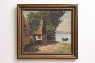 Maleri af ''house by the lake'' i gylden ramme.